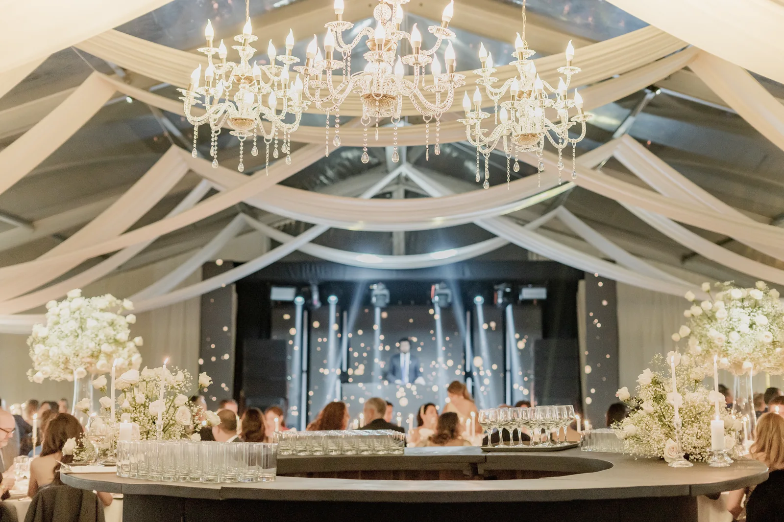 Techo en tela clara con candelabro y escenario