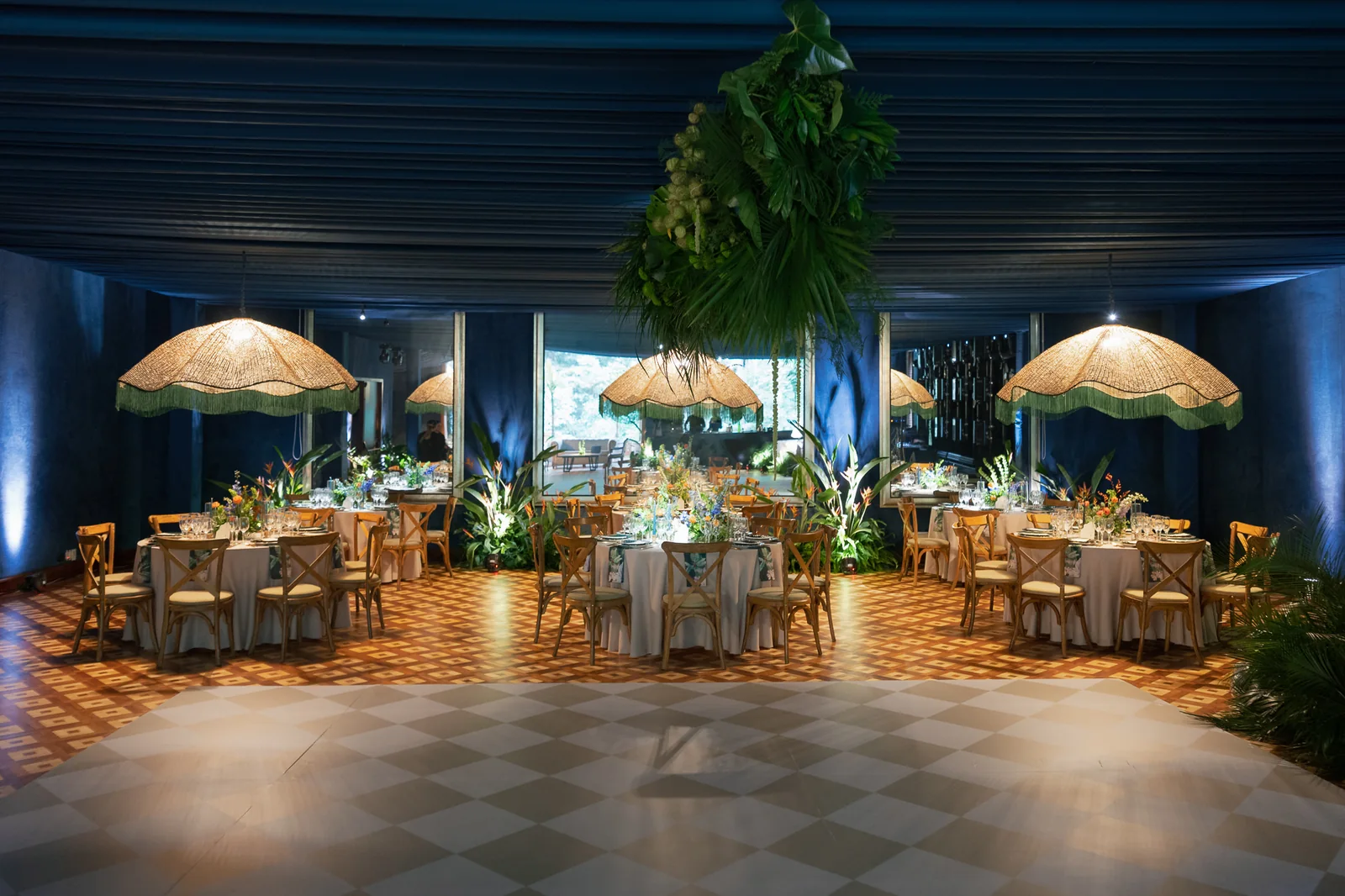 Salón en azul profundo con lámparas de fleco y pista de baile