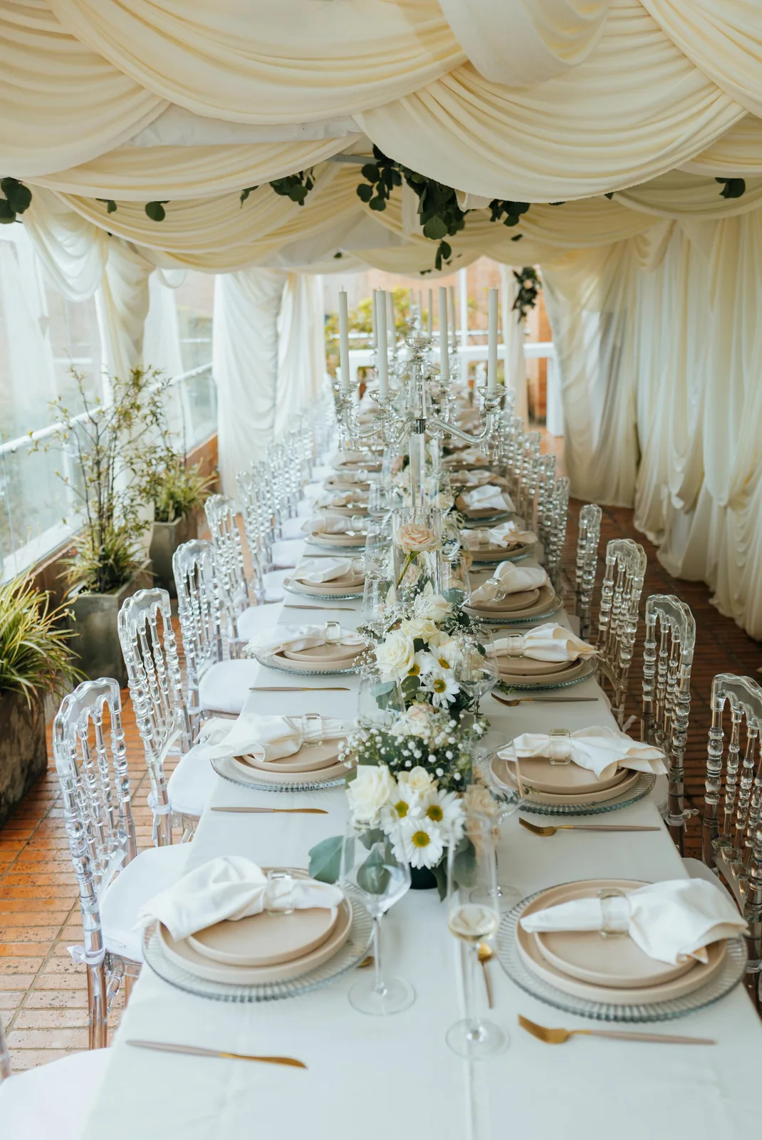 Techo plisado y mesa larga con flores blancas
