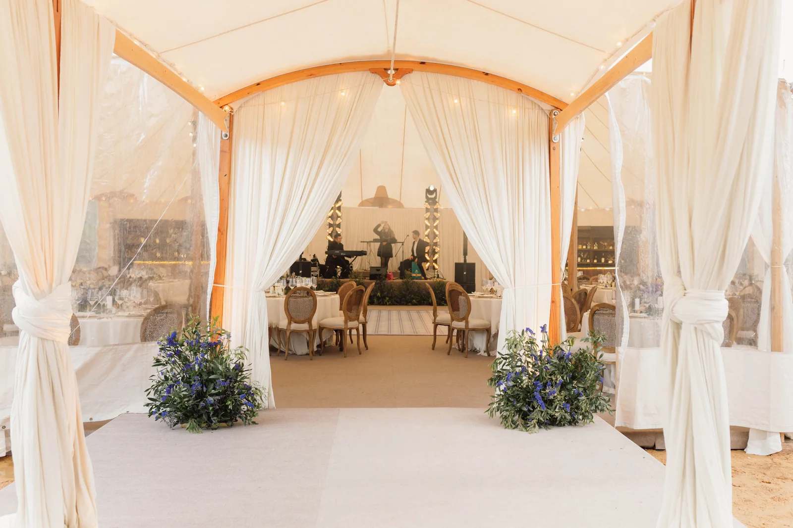 Carpa forrada en blanco con cortinas y follaje